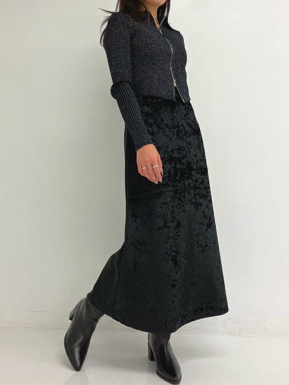 グレー系のニット/セーター、ブラック系のスカートを着用したレディースの秋コーディネートの2枚目の写真