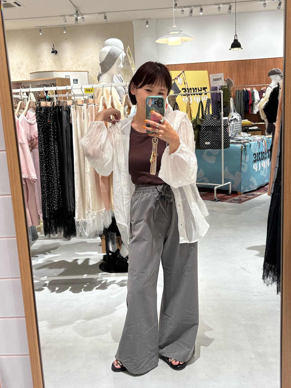 グレー系のデニムパンツ、ブラック系のサンダル、ホワイト系のシャツ/ブラウスを着用したレディースの夏コーディネートの3枚目の写真