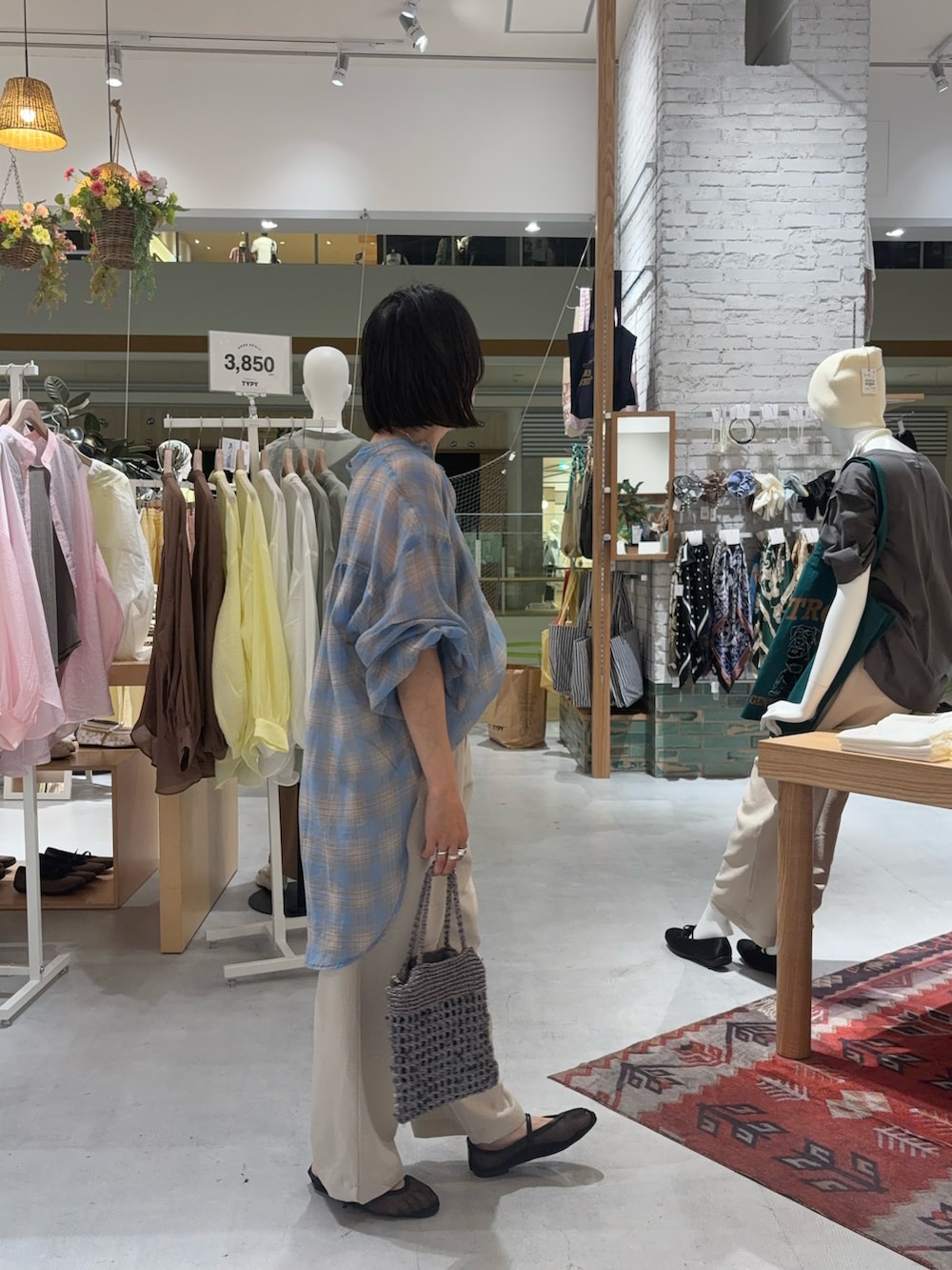 ベージュ系のその他パンツ、ブルー系のシャツ/ブラウス、グレー系のショルダーバッグを着用したレディースの夏コーディネートの3枚目の写真
