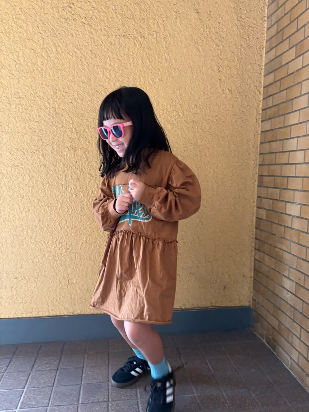 イエロー系のワンピースを着用したレディースの秋コーディネートの3枚目の写真