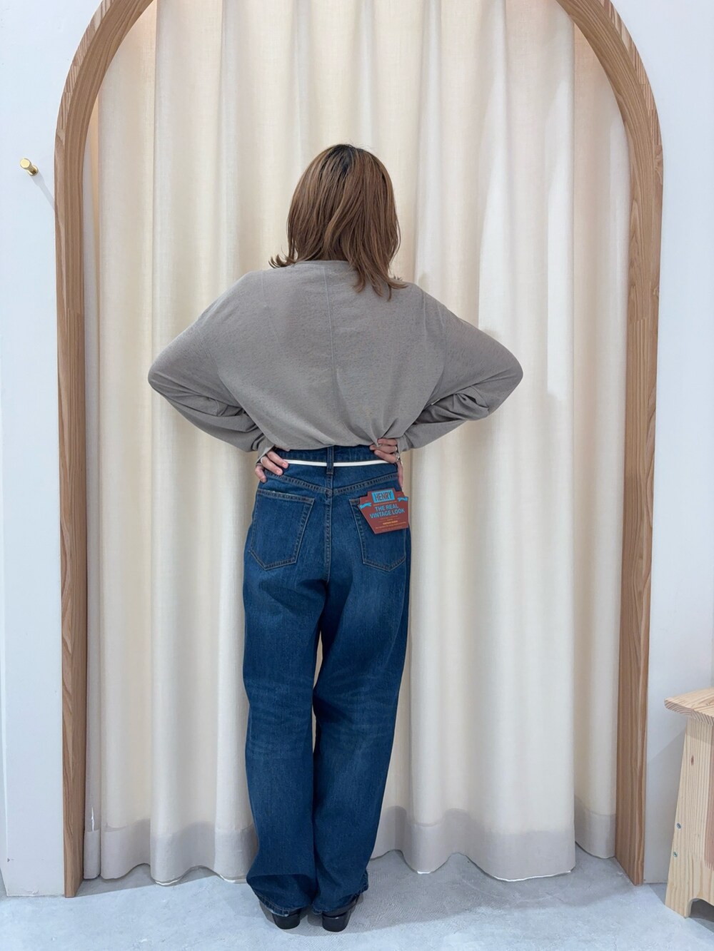 ブルー系のデニムパンツ、ベージュ系のTシャツ/カットソー、ブラック系のパンプスを着用したレディースの秋コーディネートの2枚目の写真