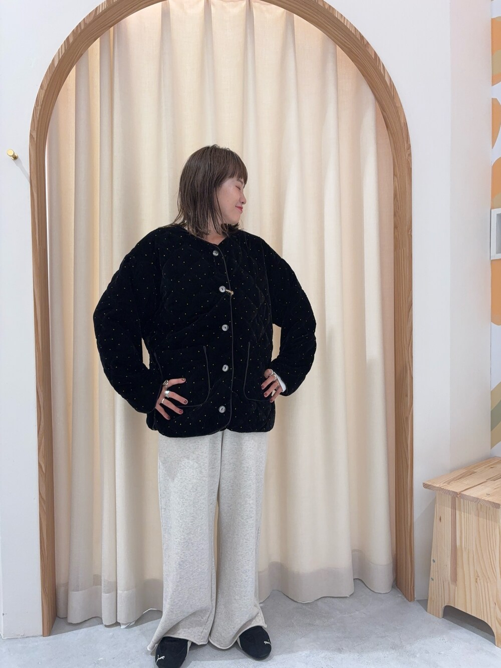 ブラック系のノーカラーコート、ホワイト系のスウェットパンツを着用したレディースの秋コーディネートの3枚目の写真