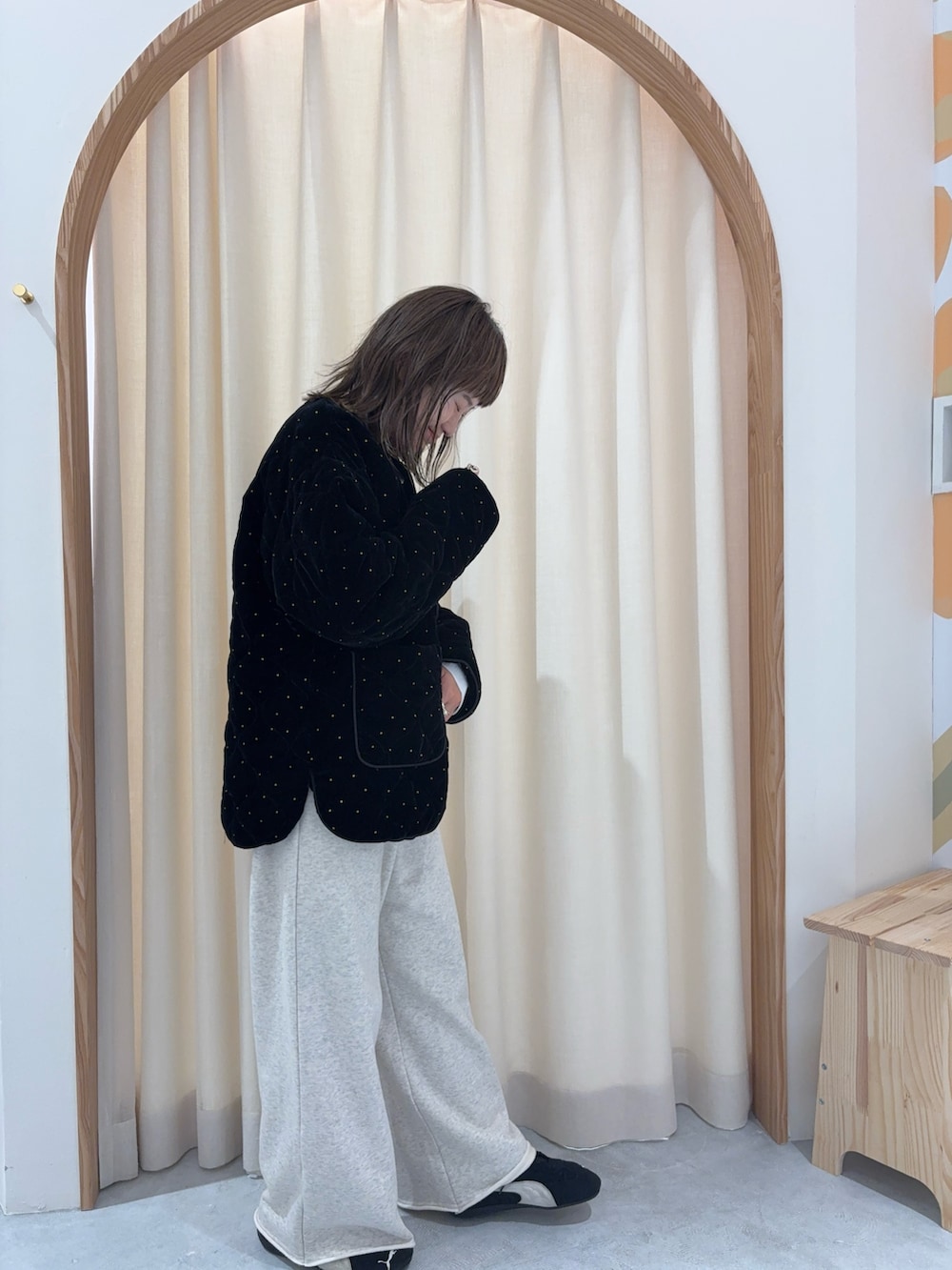 ブラック系のノーカラーコート、ホワイト系のスウェットパンツを着用したレディースの秋コーディネートの2枚目の写真