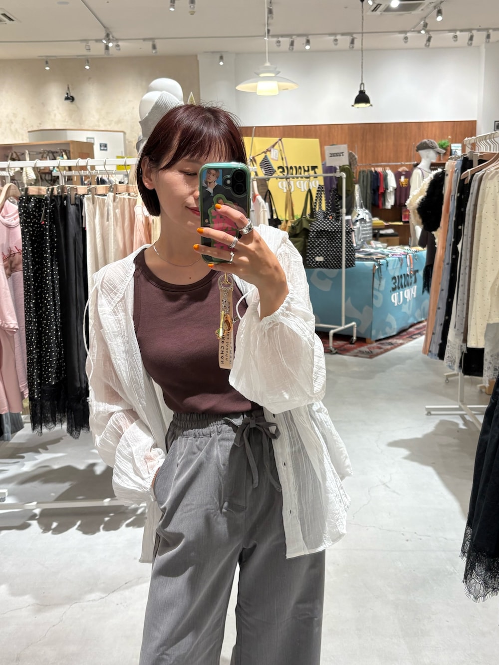 グレー系のデニムパンツ、ブラック系のサンダル、ホワイト系のシャツ/ブラウスを着用したレディースの夏コーディネートの2枚目の写真
