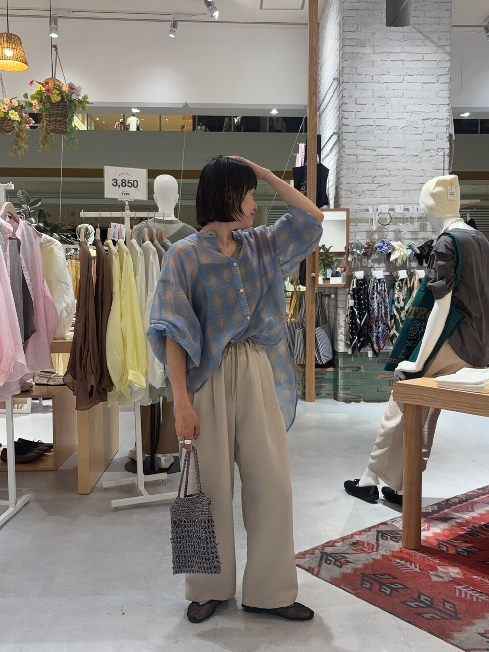 ベージュ系のその他パンツ、ブルー系のシャツ/ブラウス、グレー系のショルダーバッグを着用したレディースの夏コーディネートの2枚目の写真