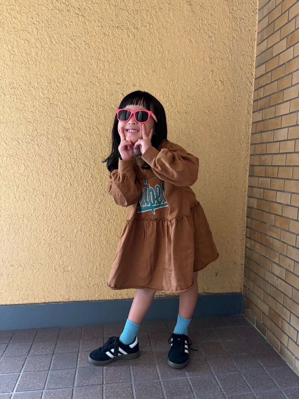 イエロー系のワンピースを着用したレディースの秋コーディネートの2枚目の写真