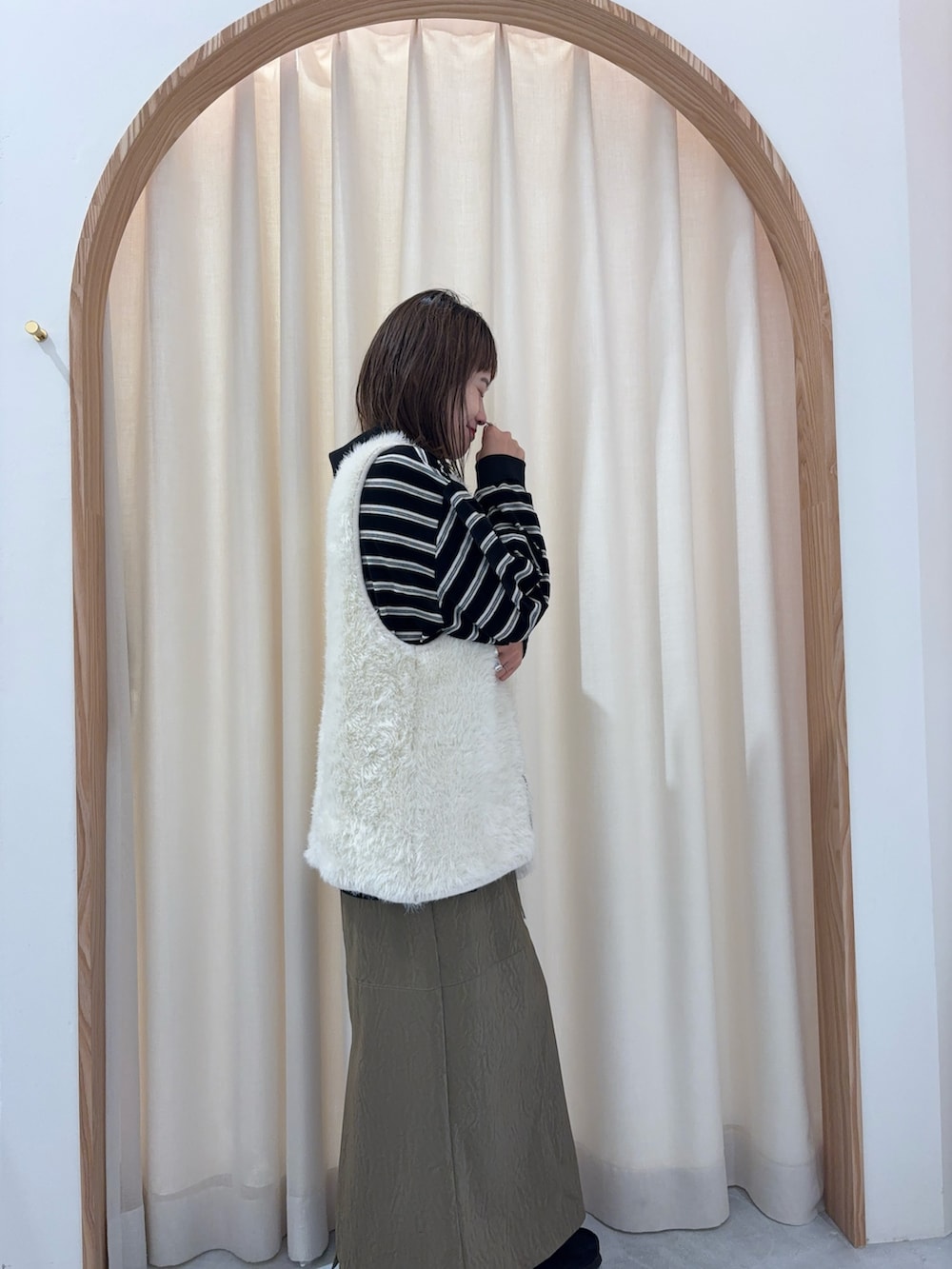 ブラック系のTシャツ/カットソー、ホワイト系のニット/セーター、グリーン系のスカートを着用したレディースの秋コーディネートの2枚目の写真