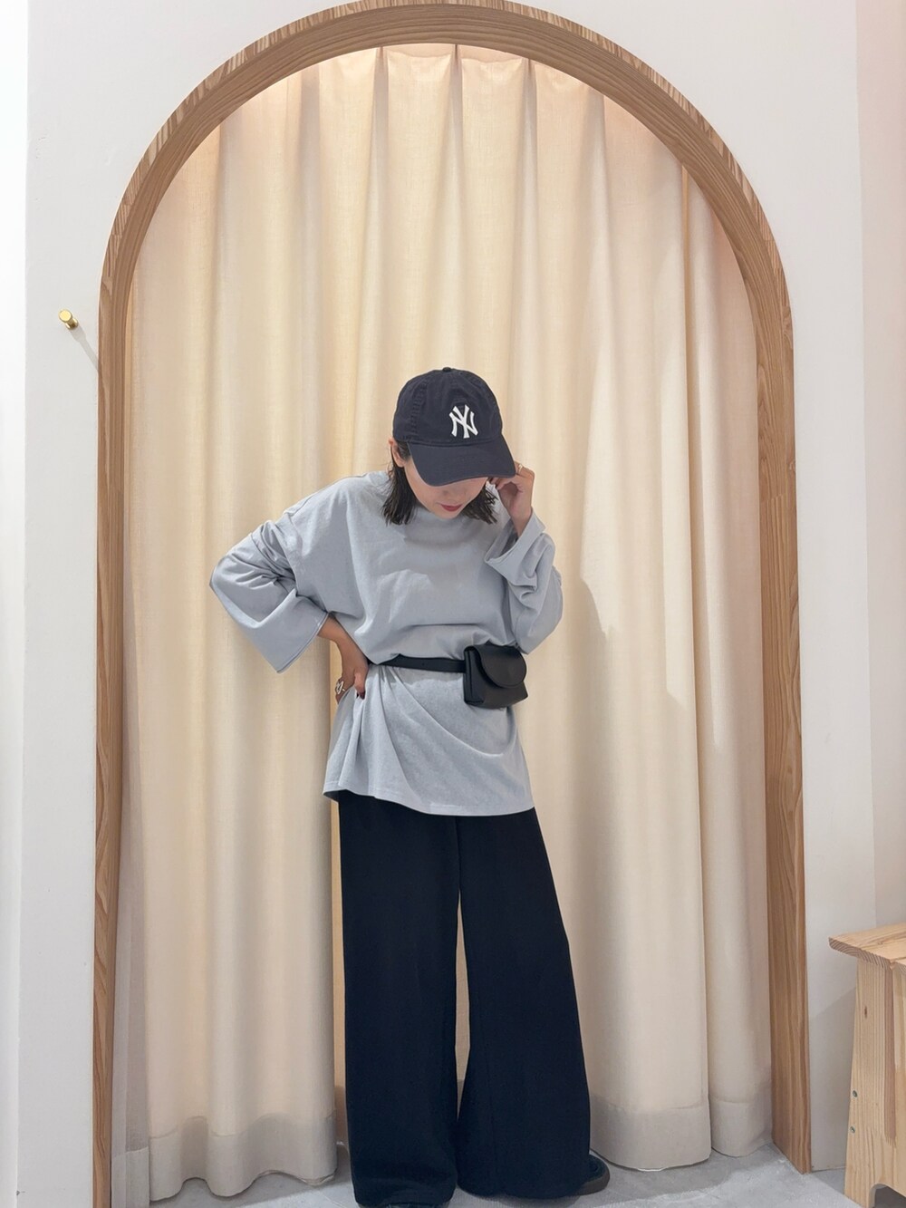 ブルー系のTシャツ/カットソー、ブラック系のショルダーバッグ、ブラック系のスウェットパンツを着用したレディースの秋コーディネートの2枚目の写真