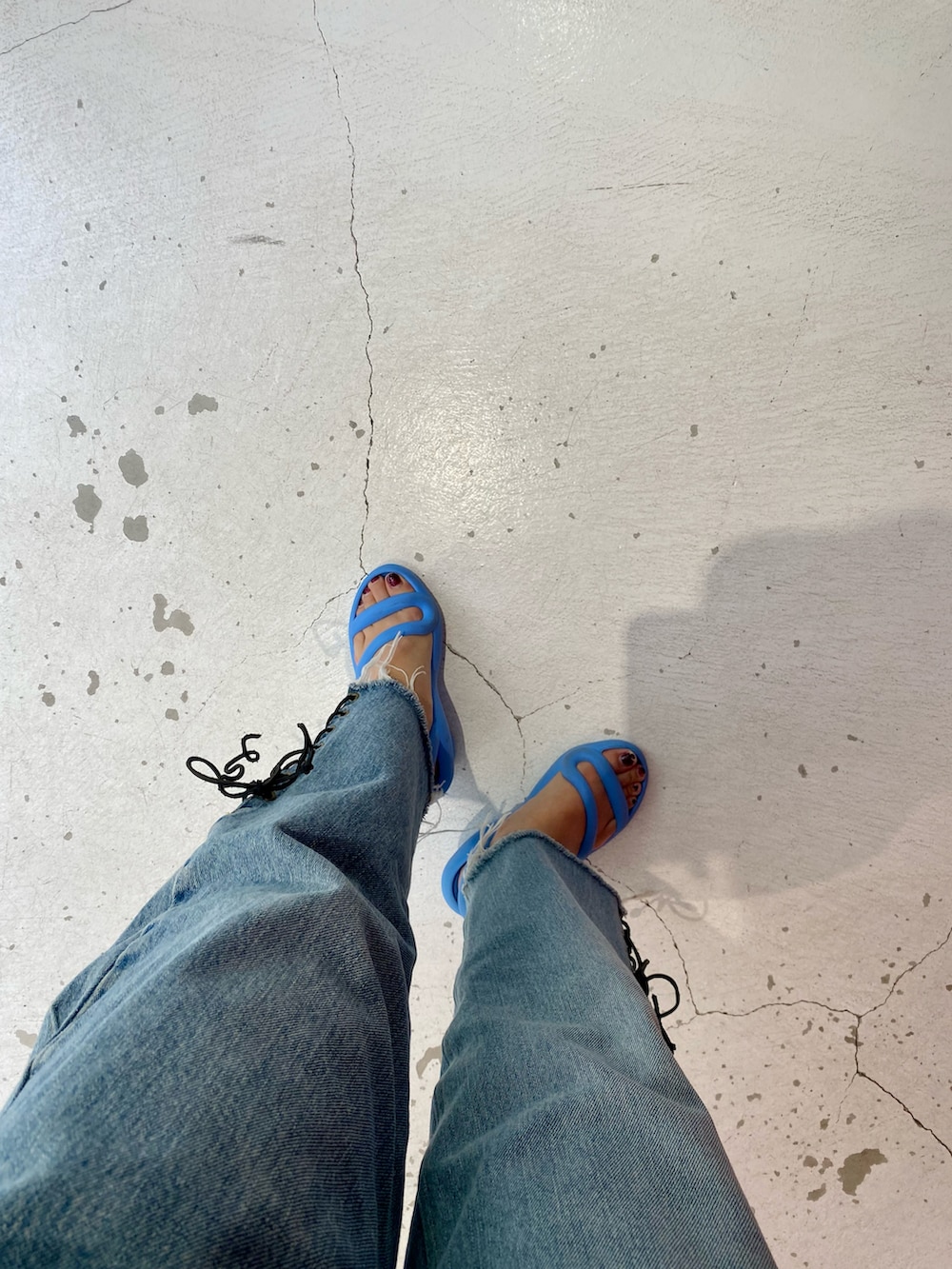 ホワイト系のシャツ/ブラウス、ブルー系のデニムパンツ、ブルー系のサンダルを着用したレディースの夏コーディネートの3枚目の写真