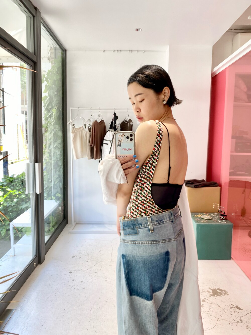 ブルー系のデニムパンツ、ブルー系のサンダル、ホワイト系のパーカーを着用したレディースの春コーディネートの2枚目の写真