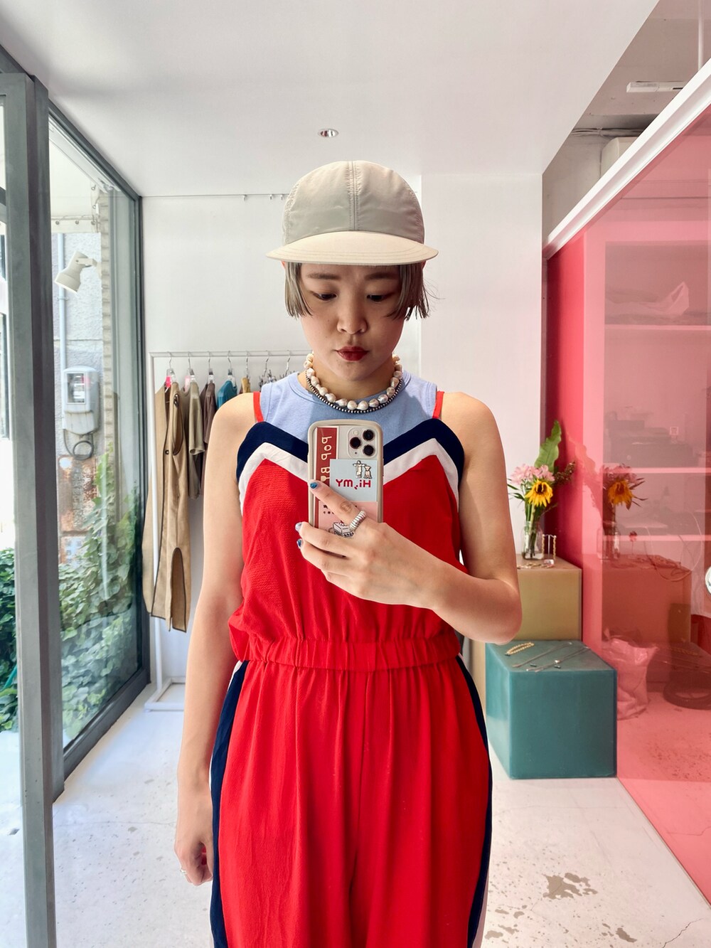 レッド系のオールインワン・サロペット、ブルー系のタンクトップ、ブルー系のサンダルを着用したレディースの夏コーディネートの2枚目の写真