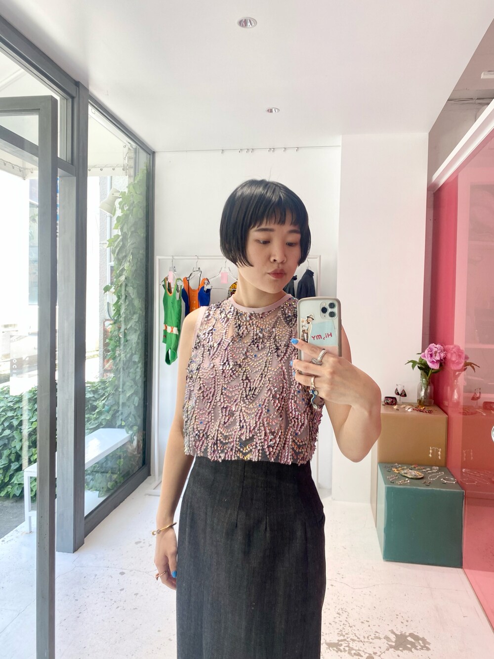 ピンク系のトップス、ブラック系のデニムスカート、グレー系のジャケット/アウターを着用したレディースの春コーディネートの2枚目の写真