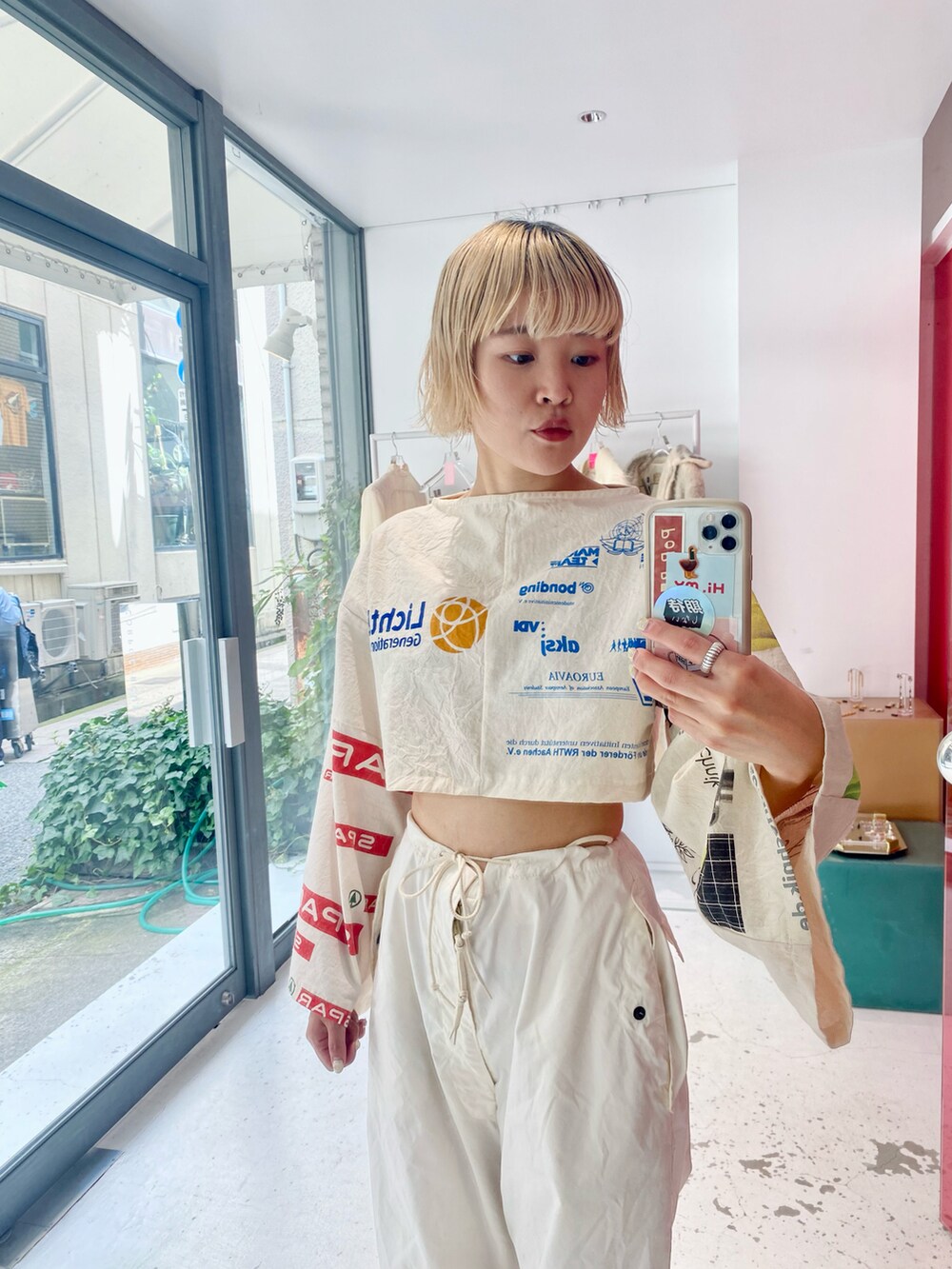 ホワイト系のパンツ、ホワイト系のトップス、ブラック系のブーツを着用したレディースの秋コーディネートの2枚目の写真