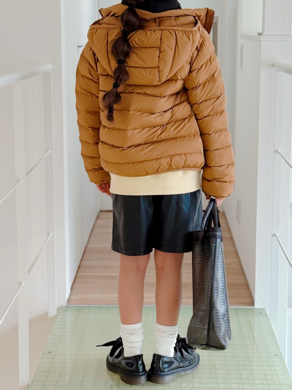 ブラック系のショルダーバッグ、ブラウン系のダウンジャケット/コート、ブラック系のその他パンツを着用したキッズの冬コーディネートの3枚目の写真