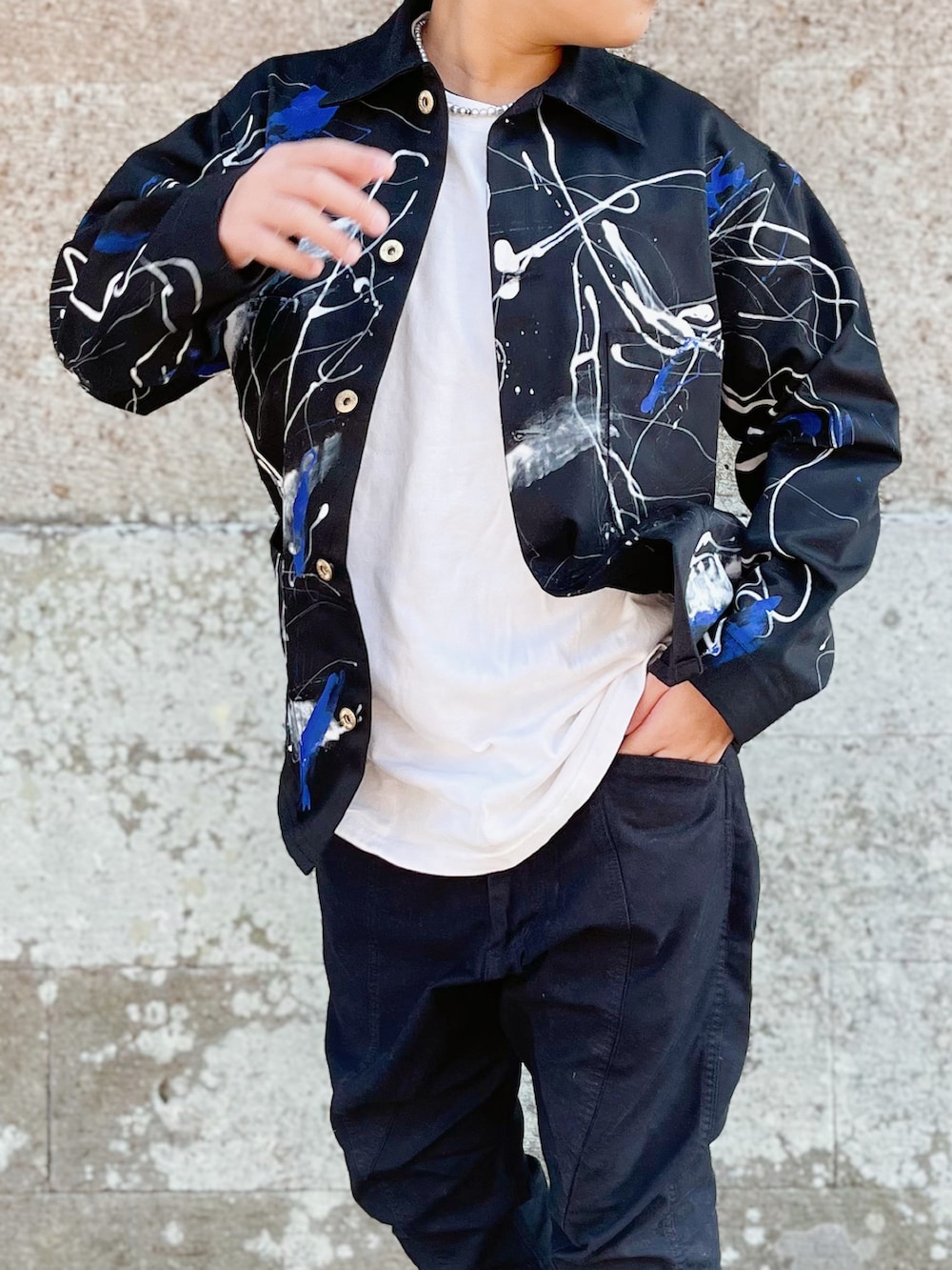 ブラック系のブルゾン、ホワイト系のTシャツ/カットソー、ブラック系のスラックスを着用したキッズの秋コーディネートの2枚目の写真