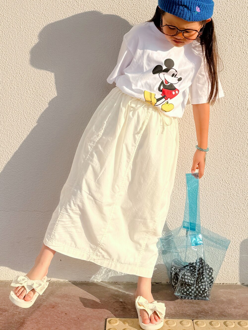 ホワイト系のTシャツ/カットソー、ホワイト系のスカート、ホワイト系のサンダルを着用したキッズの夏コーディネートの2枚目の写真