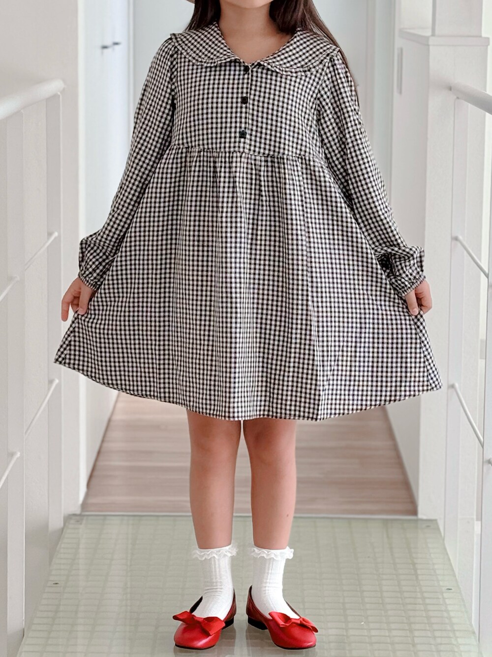 レッド系のパンプス、ブラック系のワンピース、ホワイト系のソックス/靴下を着用したキッズの夏コーディネートの2枚目の写真