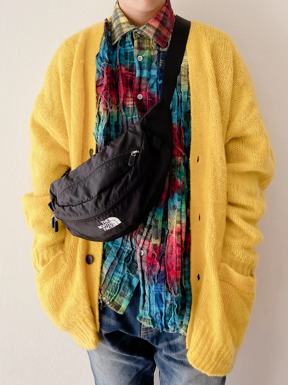 イエロー系のカーディガン/ボレロ、その他のシャツ/ブラウス、ブルー系のデニムパンツを着用したキッズの冬コーディネートの2枚目の写真