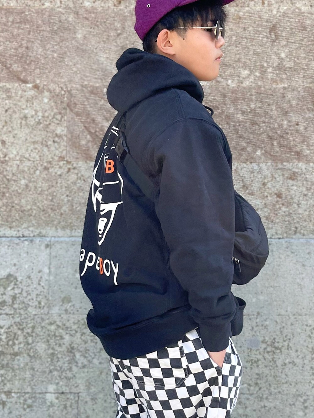 ブラック系のパーカー、ブラック系のパンツ、ホワイト系のスニーカーを着用したキッズの春コーディネートの2枚目の写真