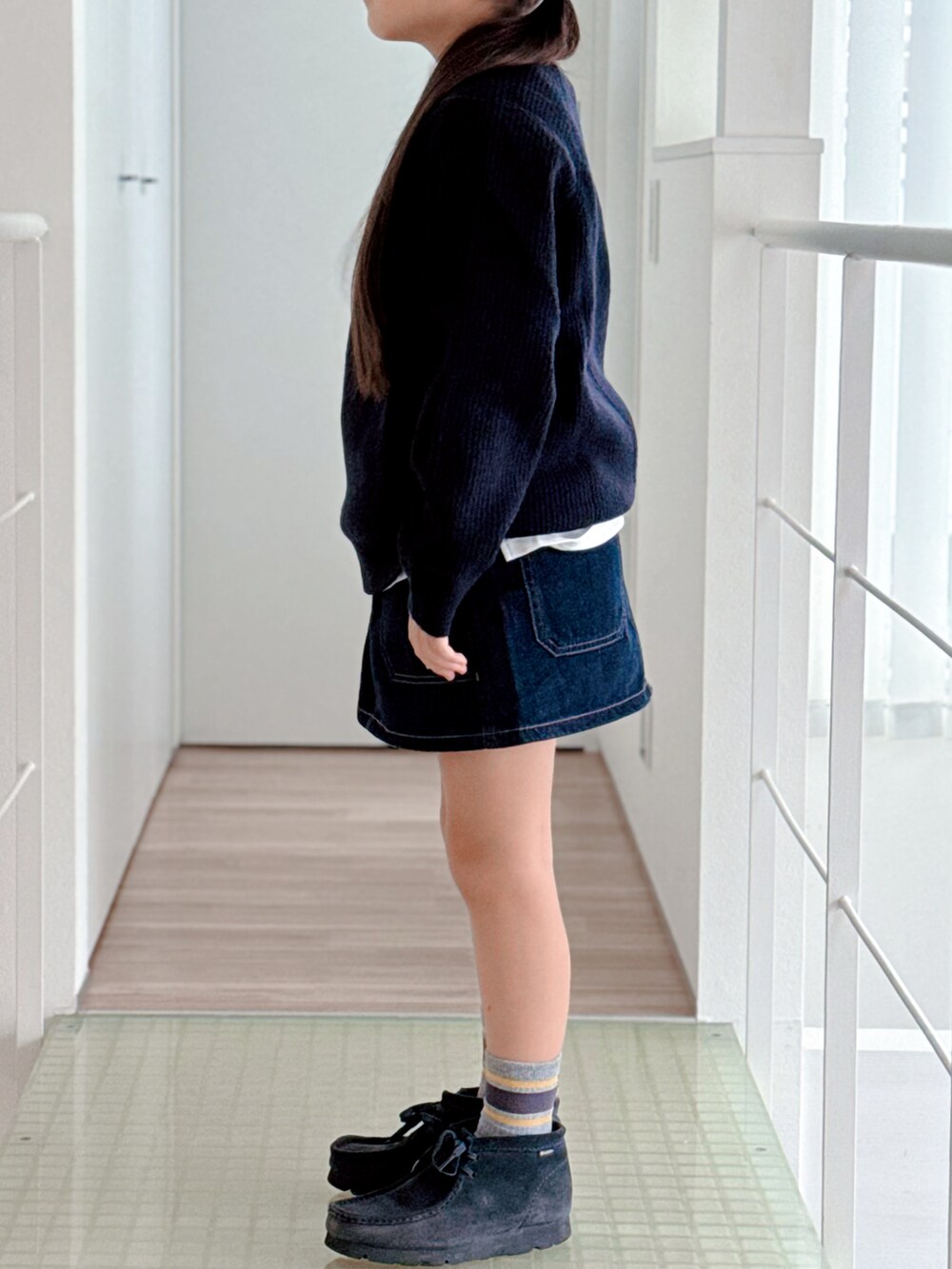 ブルー系のブーツ、ブルー系のニット/セーター、ブルー系のデニムスカートを着用したキッズの秋コーディネートの3枚目の写真