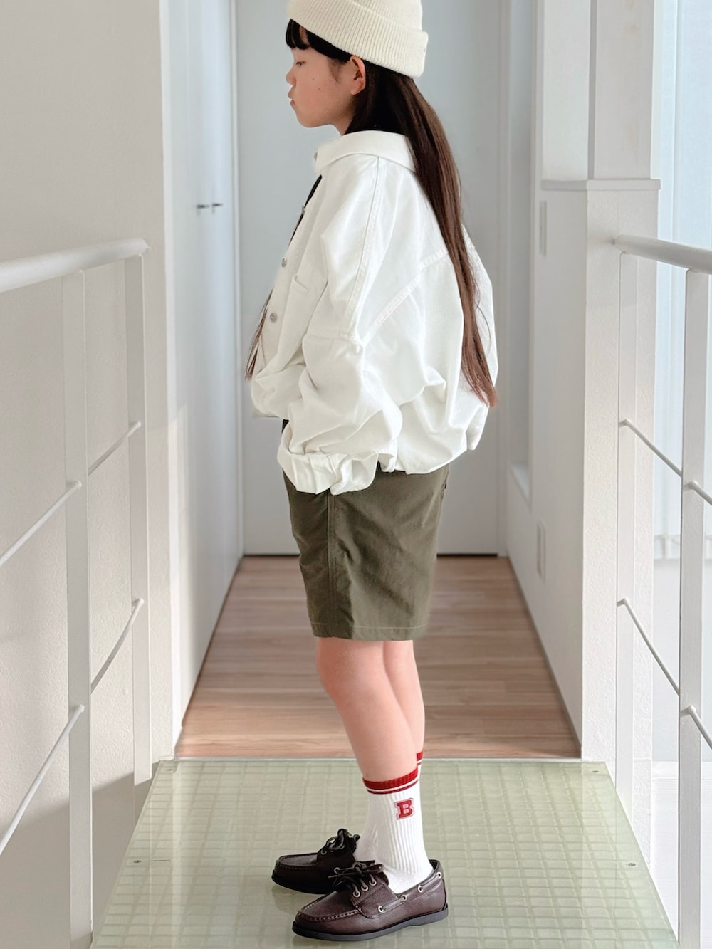 グレー系のTシャツ/カットソー、ホワイト系のデニムジャケット、グリーン系のその他パンツを着用したキッズの春コーディネートの3枚目の写真