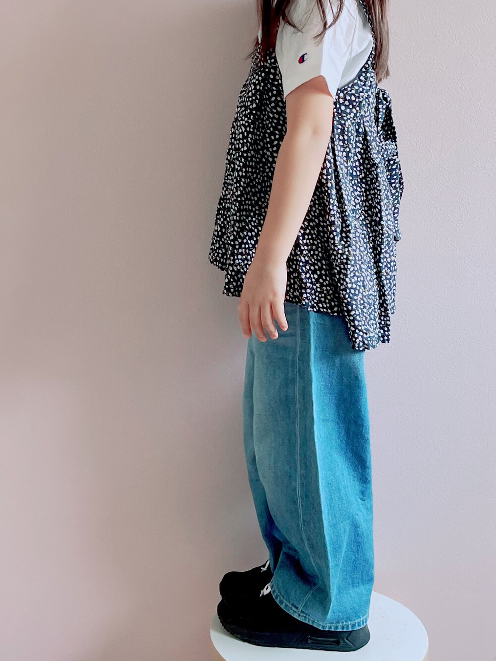 ブラック系のキャミソール、ホワイト系のTシャツ/カットソー、ブルー系のデニムパンツを着用したキッズの春コーディネートの3枚目の写真