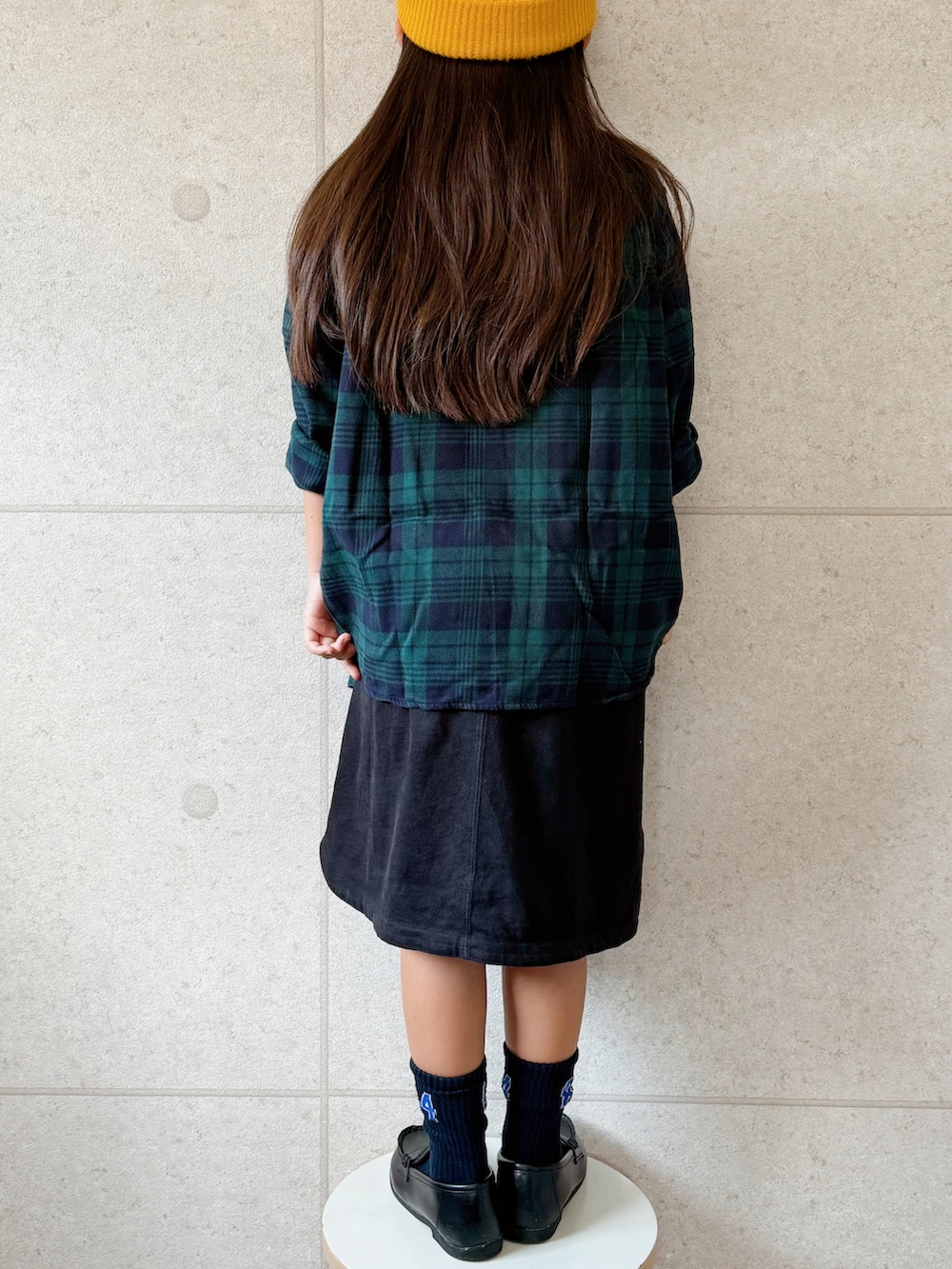 グリーン系のシャツ/ブラウス、ブラック系のワンピース、ブラック系のローファーを着用したキッズの秋コーディネートの3枚目の写真