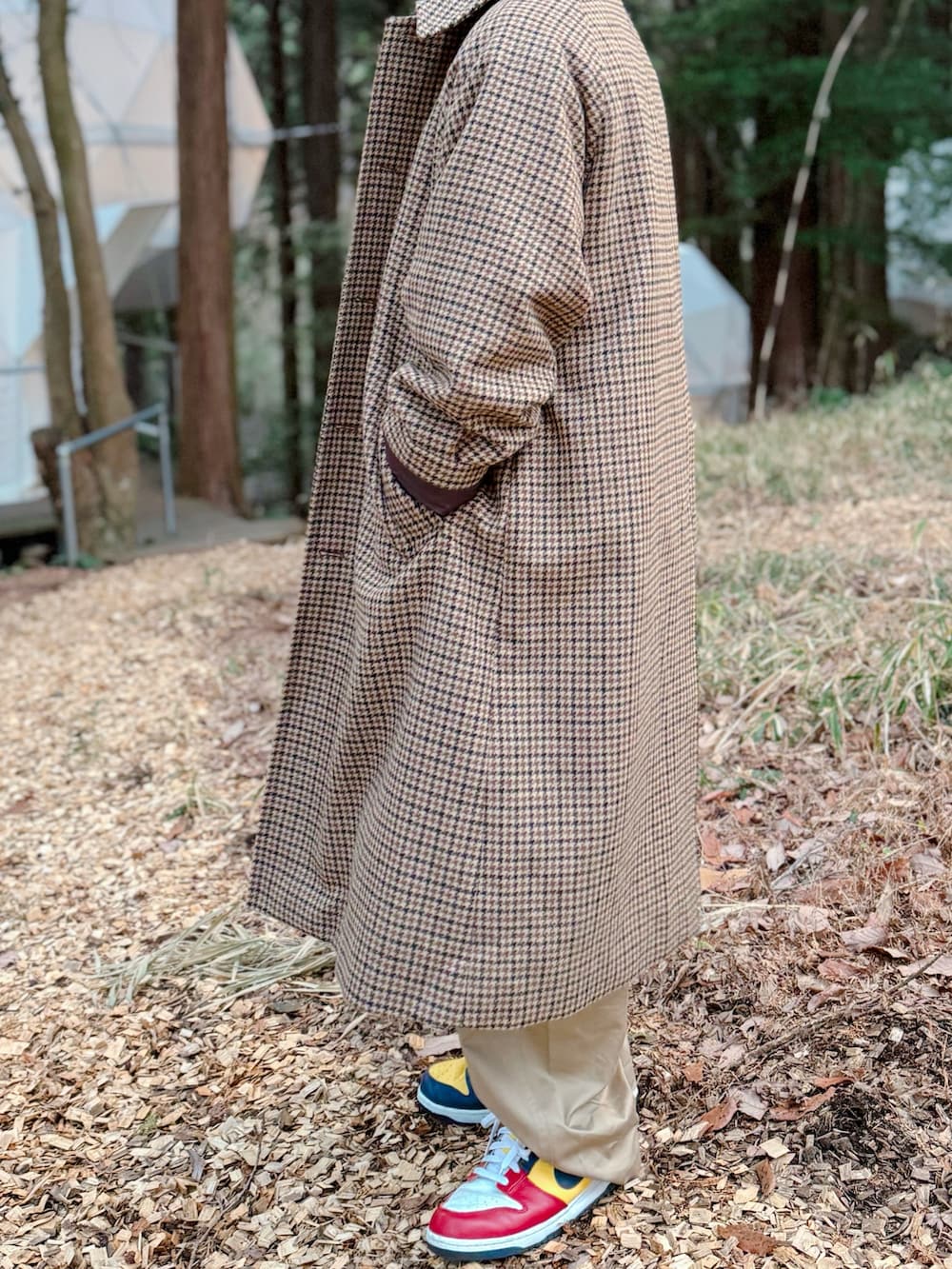 ブラウン系のステンカラーコート、ブルー系のデニムジャケット、その他のスニーカーを着用したメンズの冬コーディネートの2枚目の写真