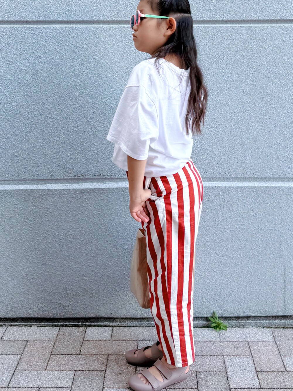 ホワイト系のTシャツ/カットソー、レッド系のその他パンツ、ブラウン系のサンダルを着用したキッズの夏コーディネートの3枚目の写真