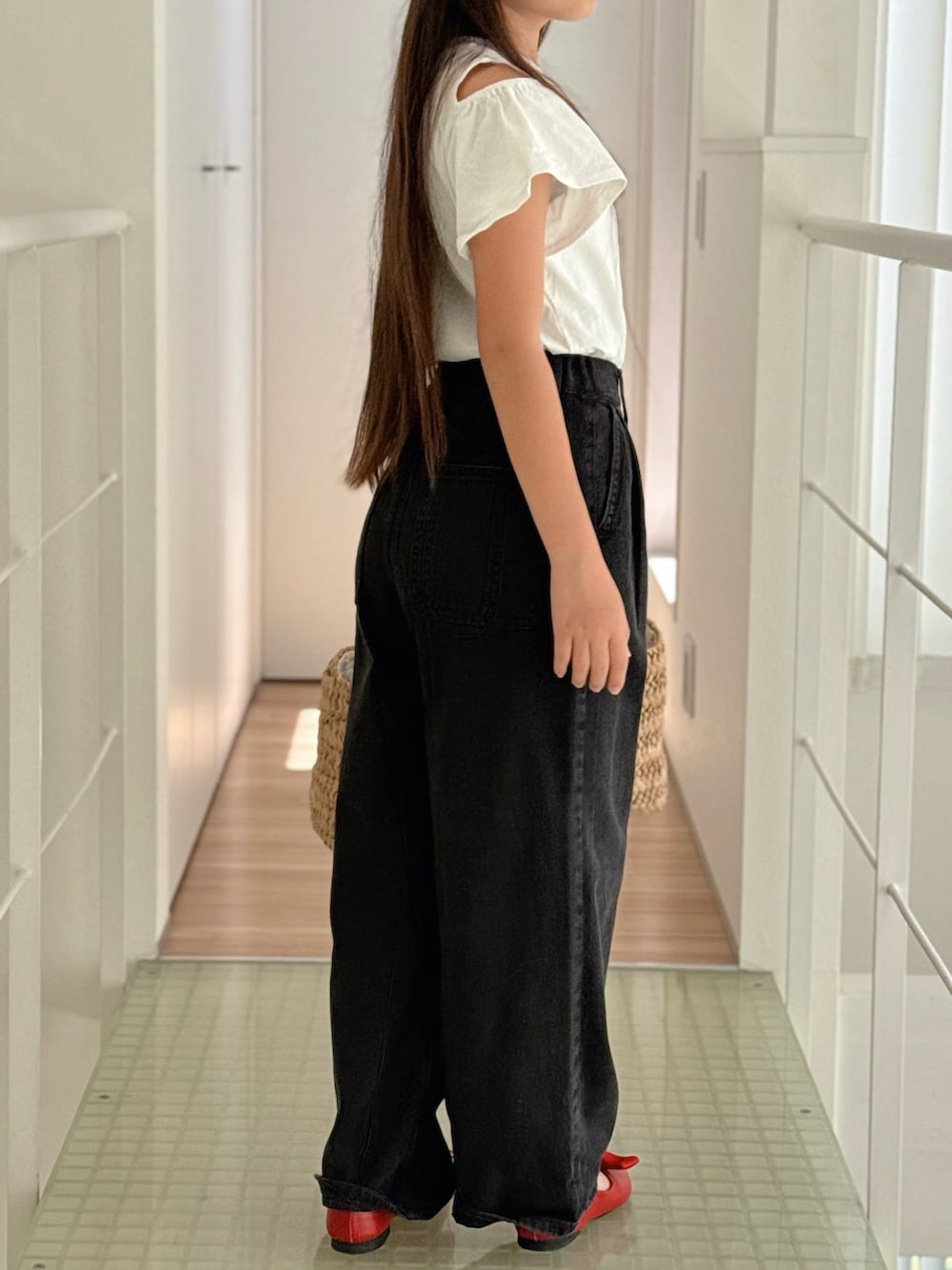 レッド系のパンプス、ホワイト系のTシャツ/カットソー、ブラック系のデニムパンツを着用したキッズの春コーディネートの3枚目の写真