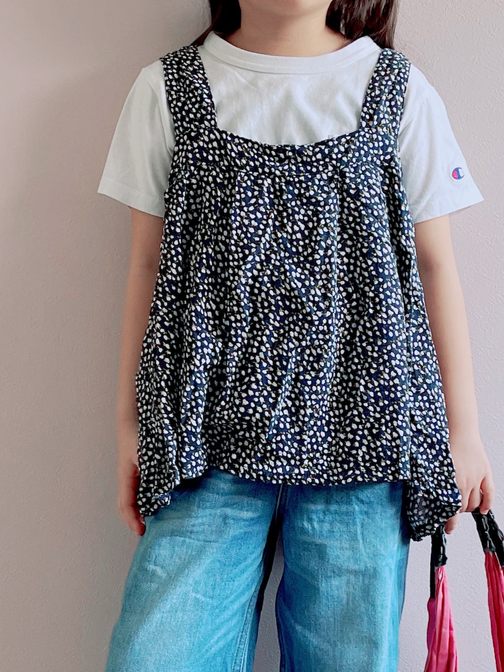 ブラック系のキャミソール、ホワイト系のTシャツ/カットソー、ブルー系のデニムパンツを着用したキッズの春コーディネートの2枚目の写真