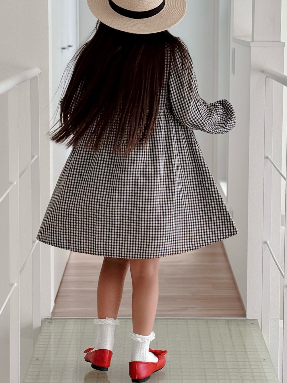 レッド系のパンプス、ブラック系のワンピース、ホワイト系のソックス/靴下を着用したキッズの夏コーディネートの3枚目の写真
