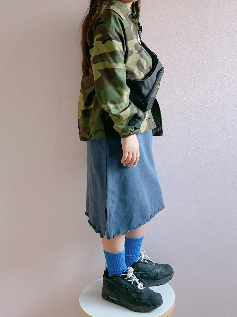 グリーン系のナイロンジャケット、ブルー系のワンピース、ブラック系のボディバッグ/ウエストポーチを着用したキッズの春コーディネートの3枚目の写真