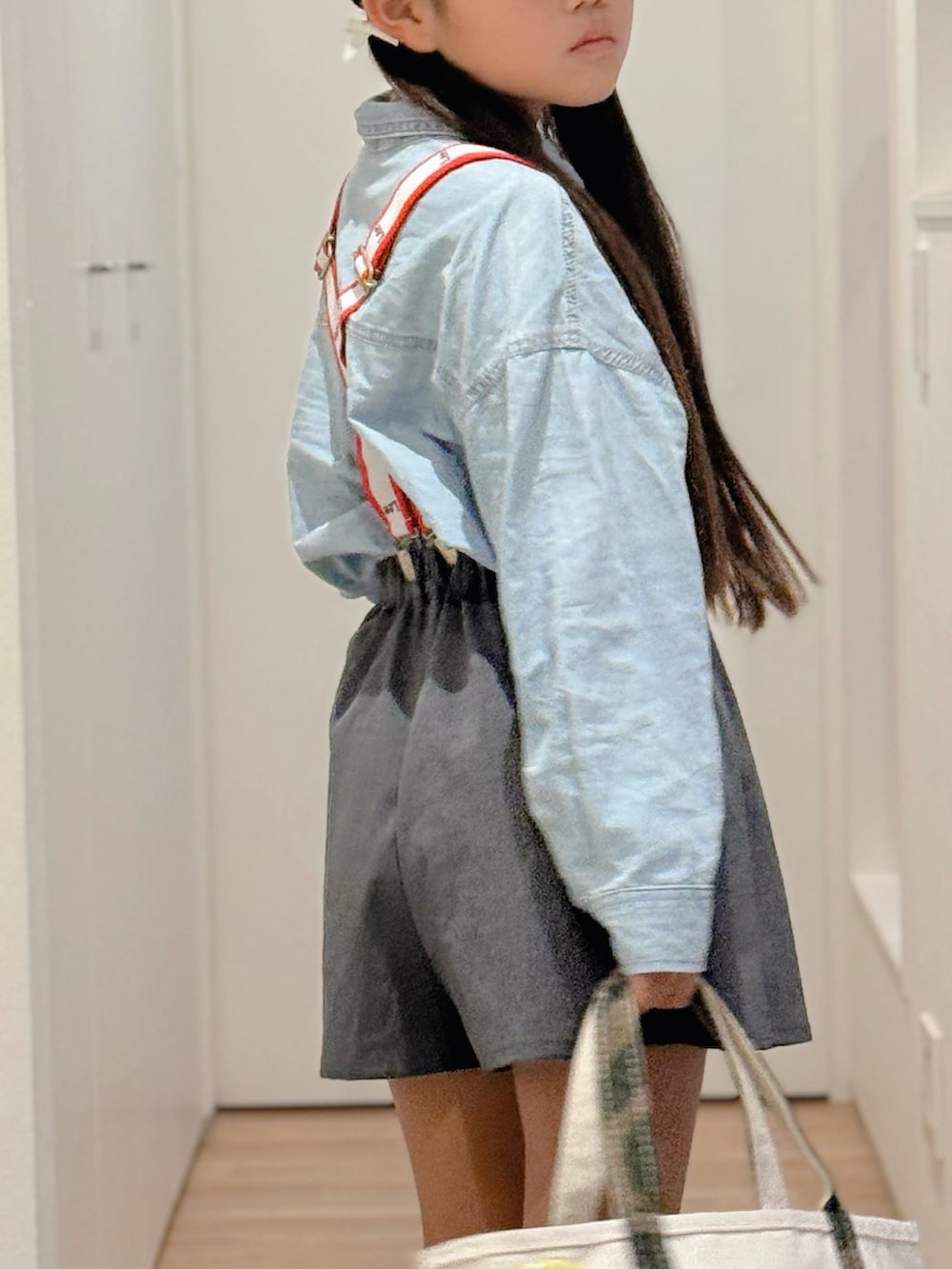 ホワイト系のトートバッグ、ブルー系のシャツ/ブラウス、グレー系のスカートを着用したキッズの秋コーディネートの2枚目の写真