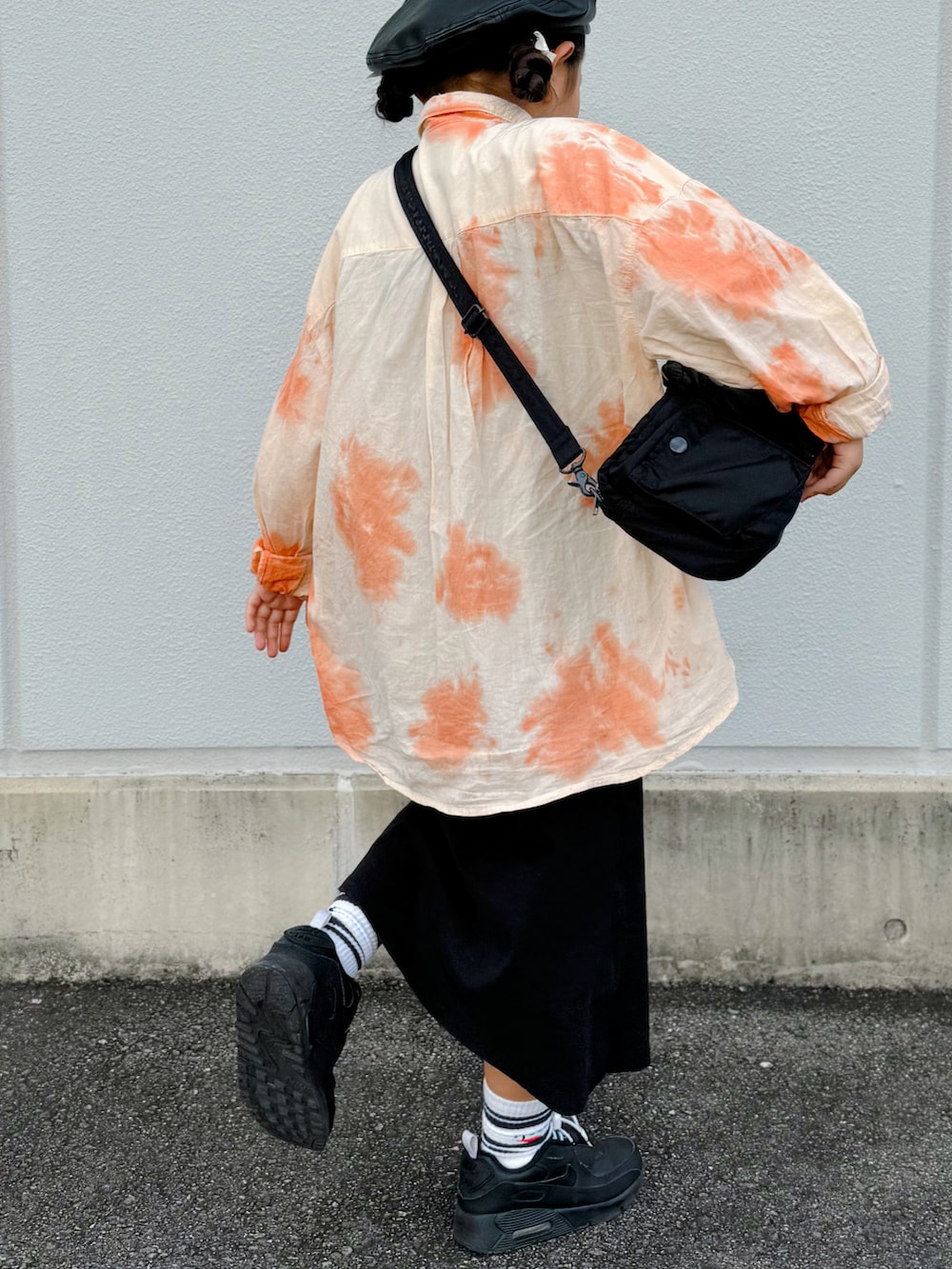 オレンジ系のシャツ/ブラウス、ブラック系のスカート、ブラック系のスニーカーを着用したキッズの秋コーディネートの2枚目の写真