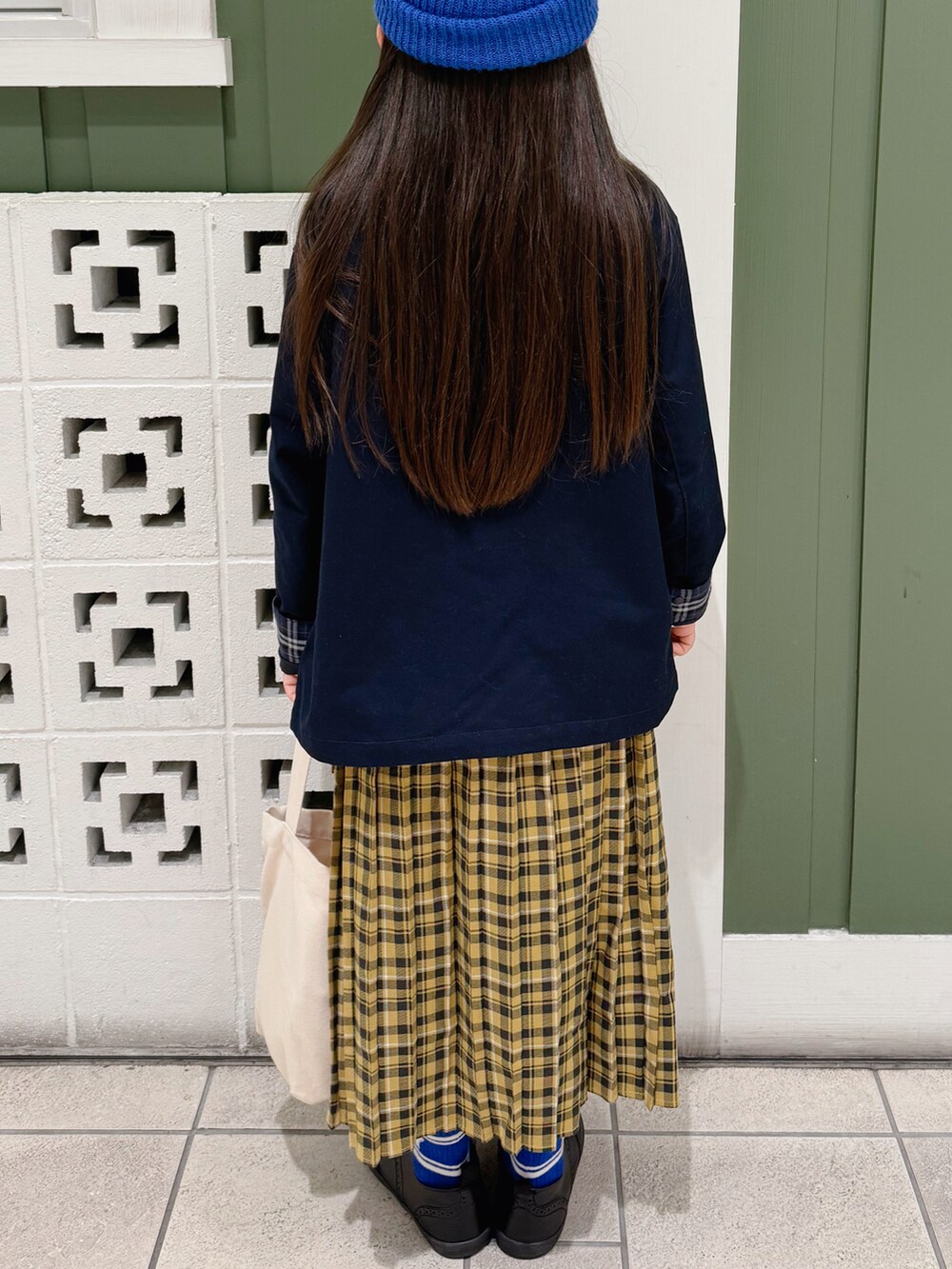 ブルー系のブルゾン、ホワイト系のシャツ/ブラウス、イエロー系のスカートを着用したキッズの秋コーディネートの3枚目の写真