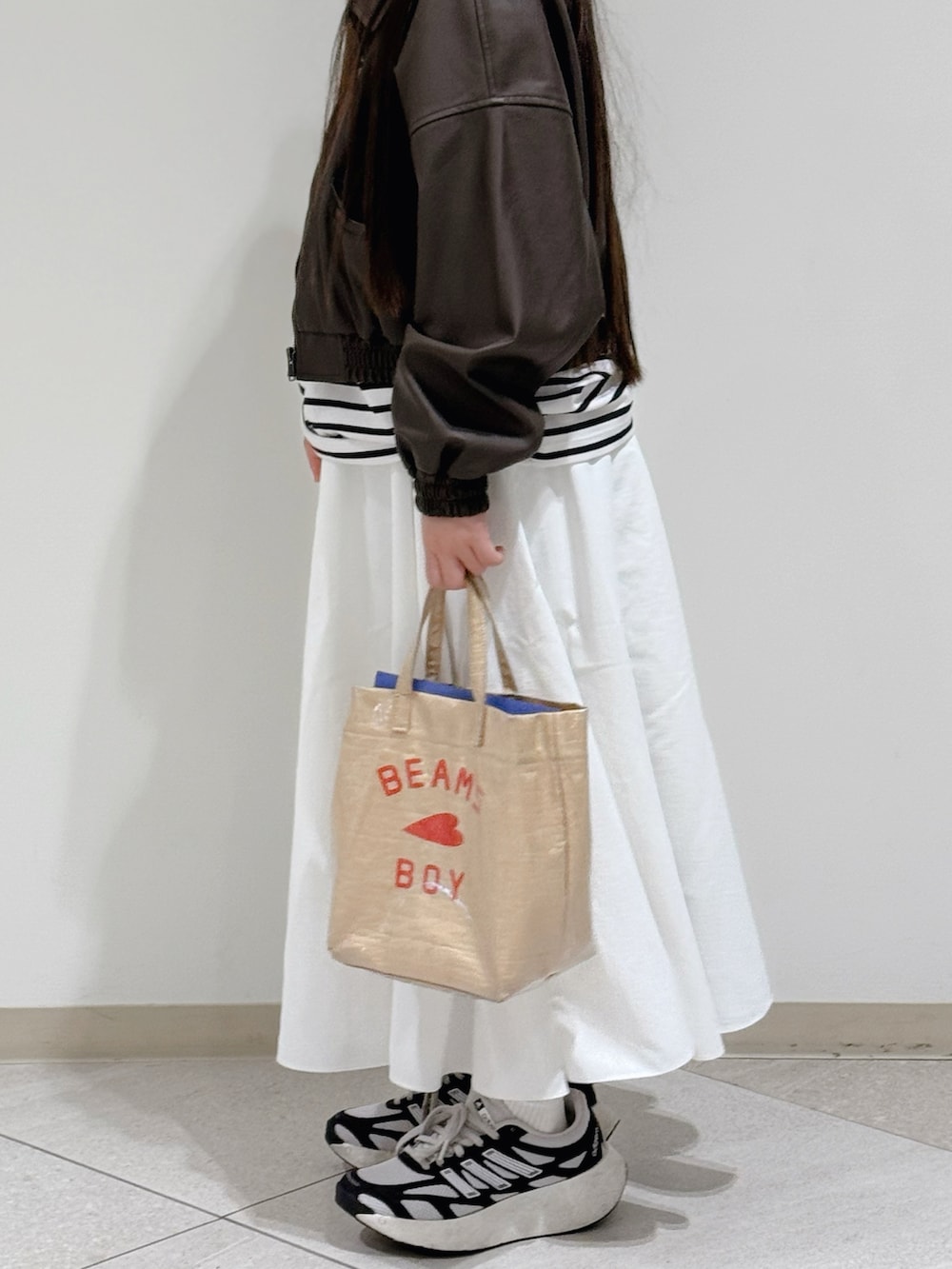 ホワイト系のスニーカー、ベージュ系のトートバッグ、ブラウン系のブルゾンを着用したキッズの春コーディネートの2枚目の写真