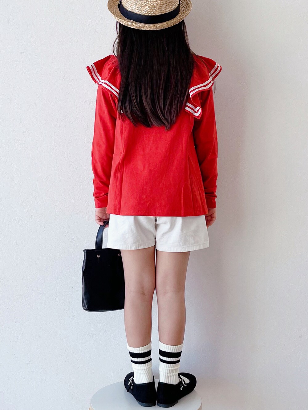 レッド系のTシャツ/カットソー、ホワイト系のその他パンツ、ブラック系のショルダーバッグを着用したキッズの春コーディネートの3枚目の写真