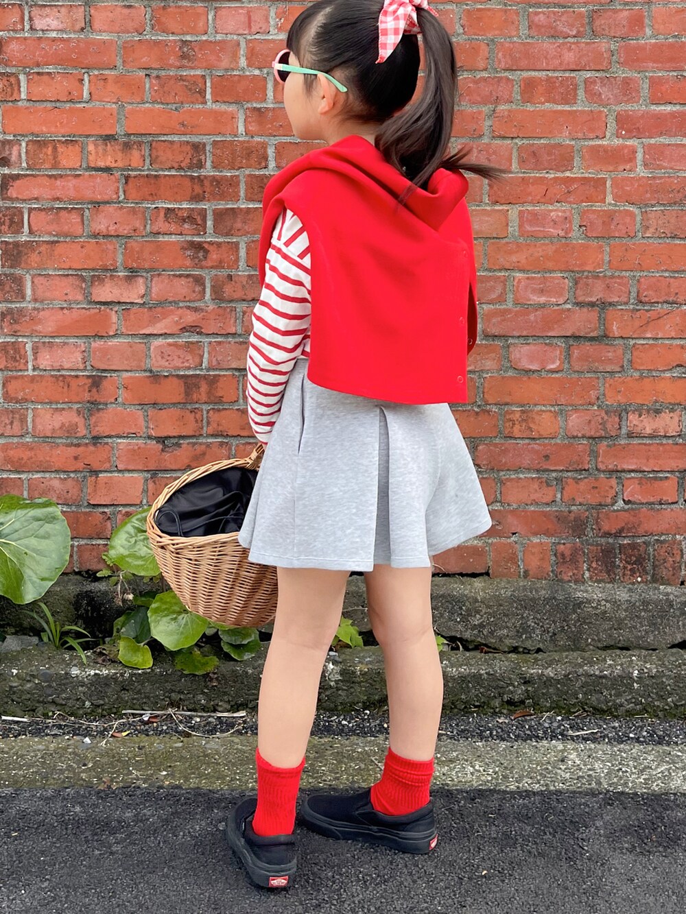 レッド系のTシャツ/カットソー、レッド系のカーディガン/ボレロ、グレー系のスカートを着用したキッズの春コーディネートの3枚目の写真