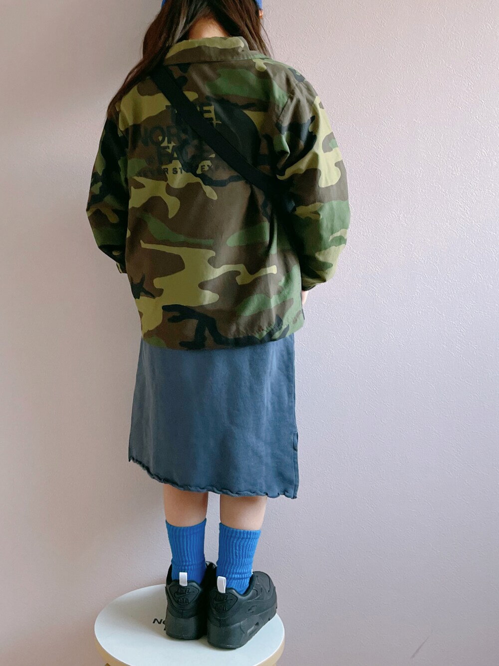 グリーン系のナイロンジャケット、ブルー系のワンピース、ブラック系のボディバッグ/ウエストポーチを着用したキッズの春コーディネートの4枚目の写真