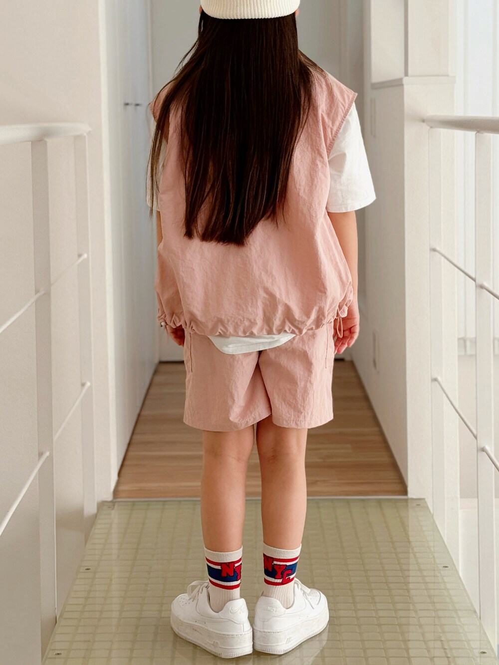 ホワイト系のスニーカー、ホワイト系のTシャツ/カットソー、ピンク系のベストを着用したキッズの春コーディネートの4枚目の写真