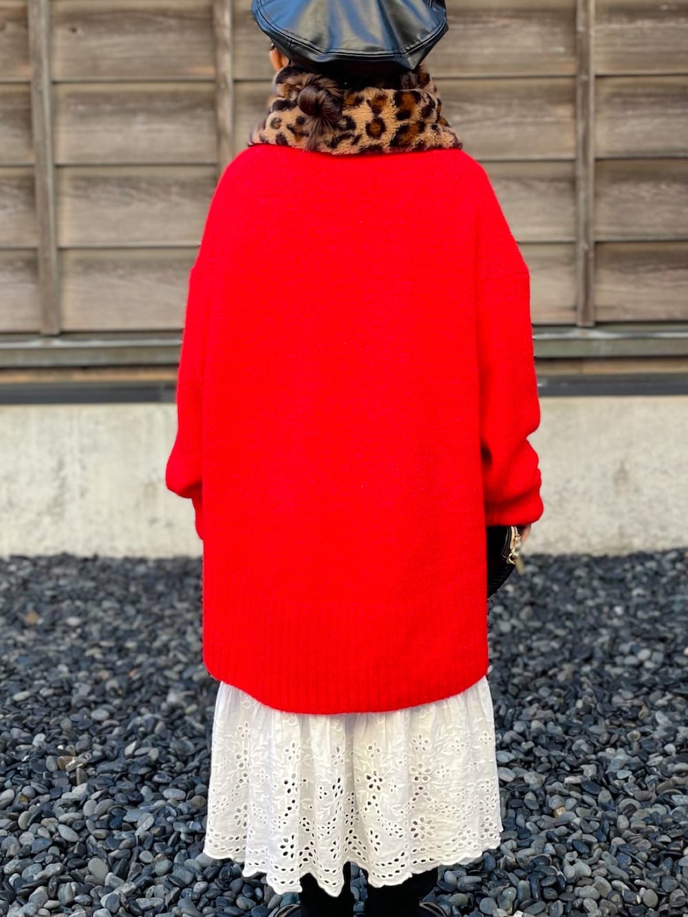 レッド系のニット/セーター、ホワイト系のスカート、ブラック系のブーツを着用したキッズの冬コーディネートの3枚目の写真