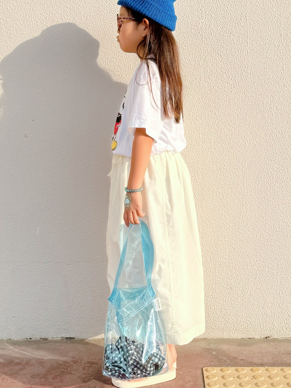 ホワイト系のTシャツ/カットソー、ホワイト系のスカート、ホワイト系のサンダルを着用したキッズの夏コーディネートの3枚目の写真