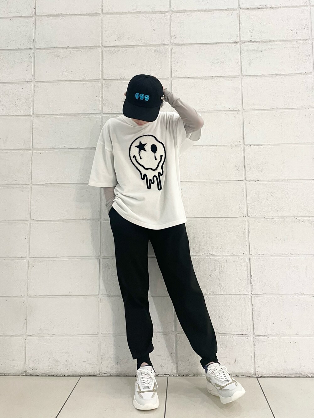 ブラック系のその他パンツ、ホワイト系のTシャツ/カットソー、ゴールド系のスニーカーを着用したレディースの春コーディネートの2枚目の写真