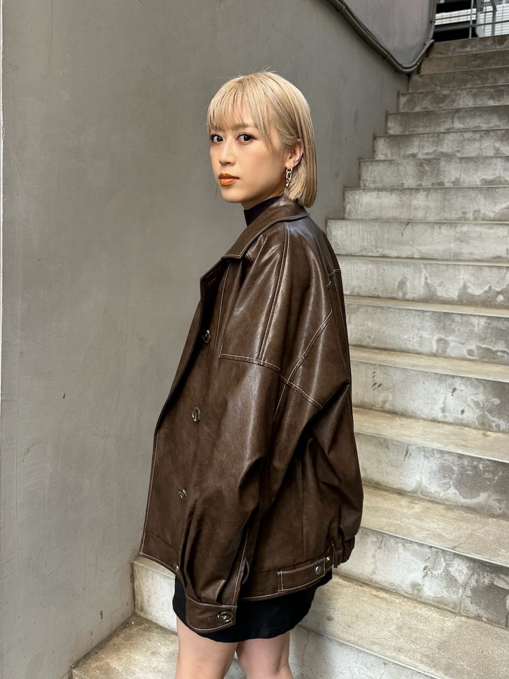 ブラウン系のブルゾンを着用したレディースの夏コーディネートの2枚目の写真