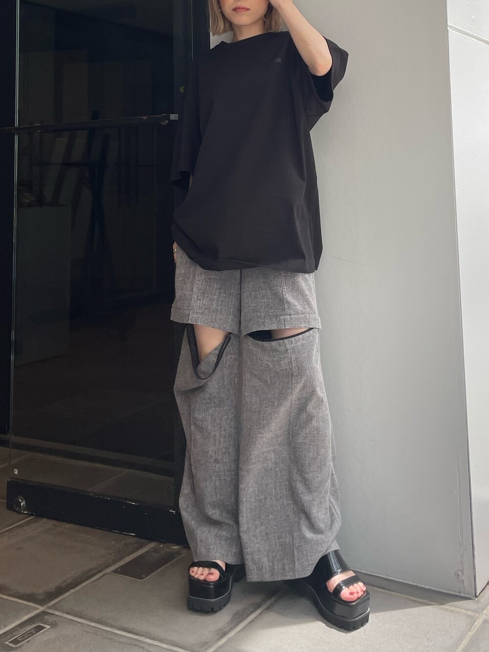 ブラック系のTシャツ/カットソー、グレー系のスラックスを着用したレディースの春コーディネートの2枚目の写真