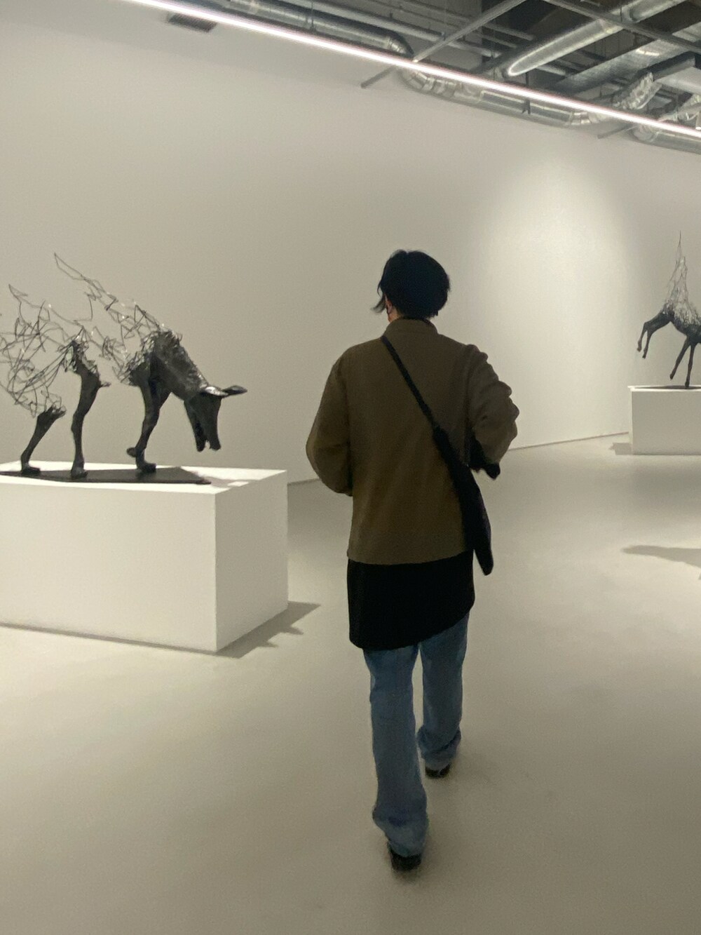 ブラウン系のテーラードジャケット、ブラック系のトップス、オレンジ系のTシャツ/カットソーを着用したメンズの冬コーディネートの2枚目の写真