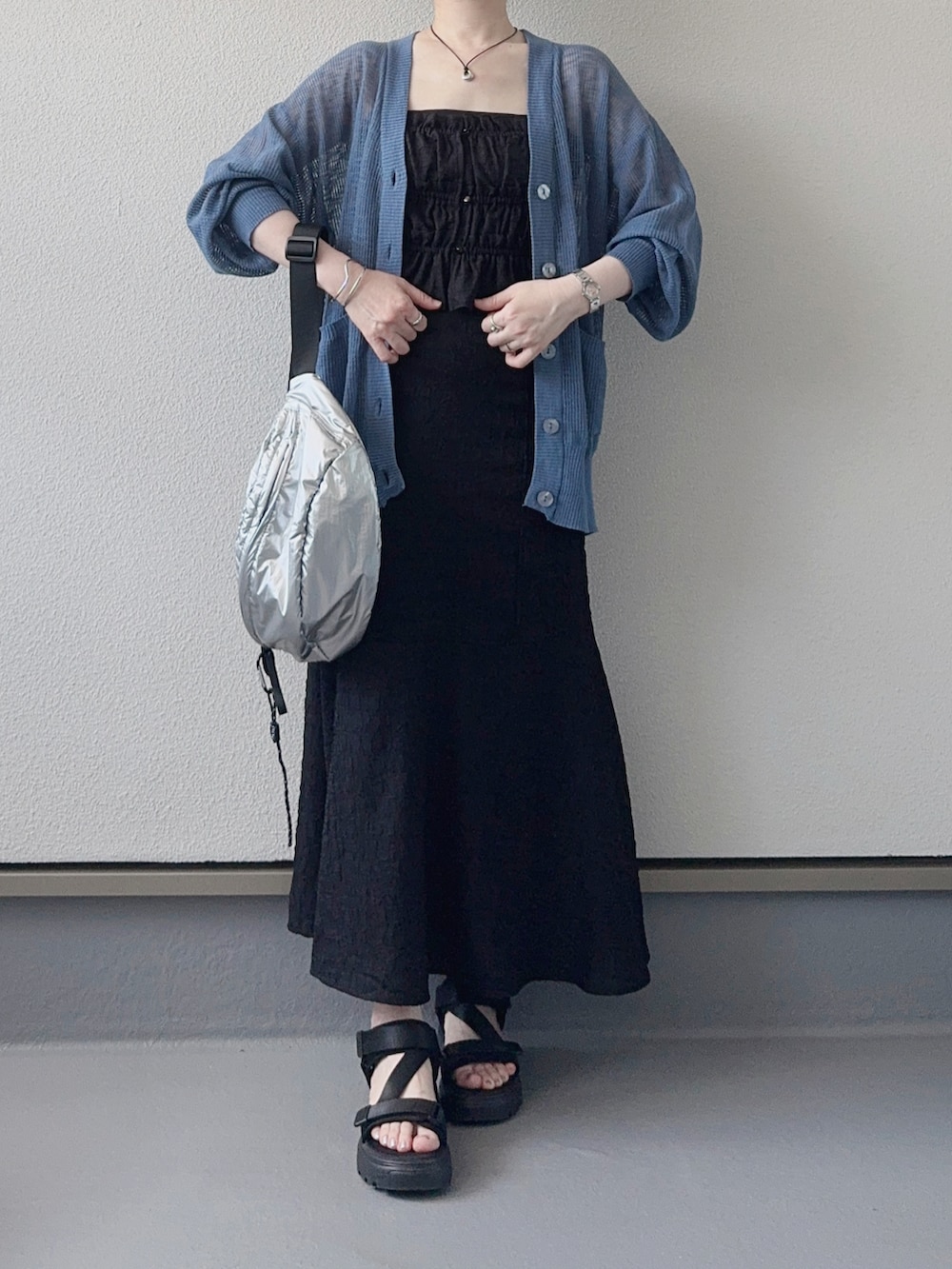 ブルー系のカーディガン/ボレロ、ブラック系のワンピース、シルバー系のボディバッグ/ウエストポーチを着用したレディースの夏コーディネートの3枚目の写真