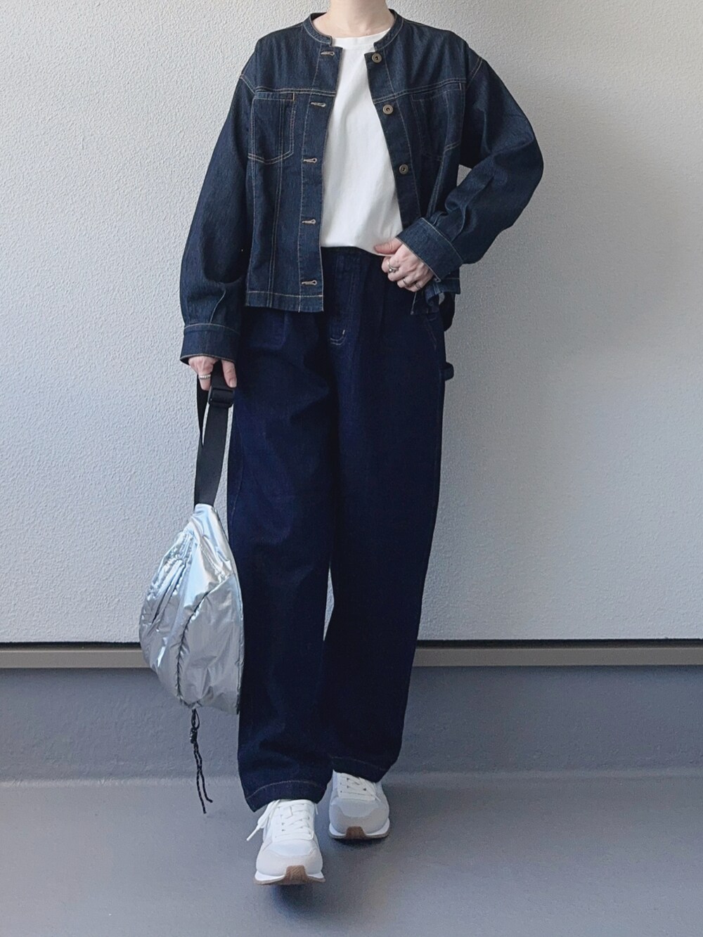 シルバー系のボディバッグ/ウエストポーチ、ブルー系のブルゾン、ブルー系のデニムパンツを着用したレディースの秋コーディネートの3枚目の写真
