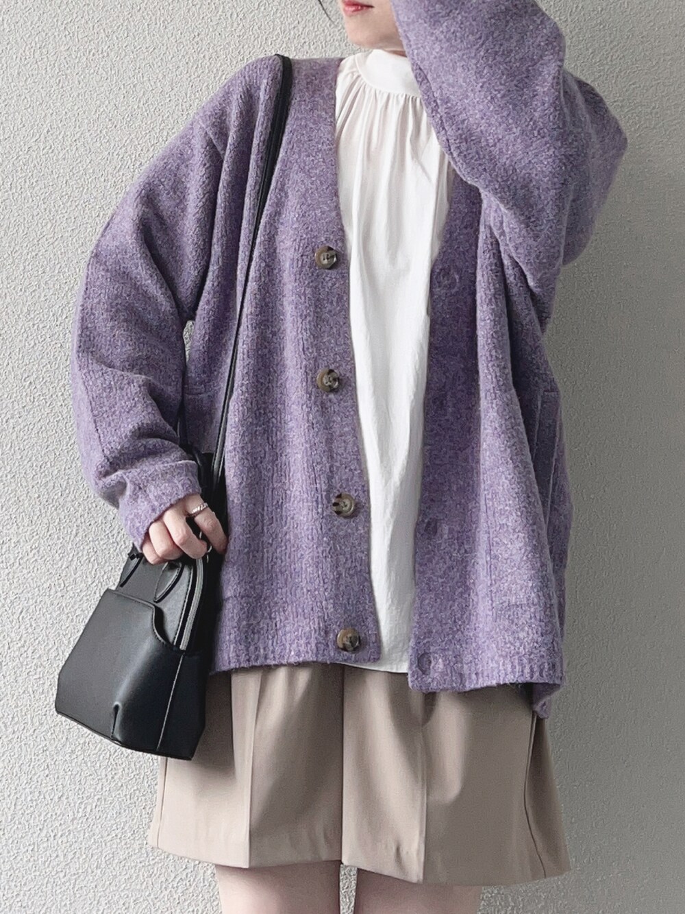 パープル系のカーディガン/ボレロ、ホワイト系のシャツ/ブラウス、ベージュ系のパンツを着用したレディースの秋コーディネートの3枚目の写真